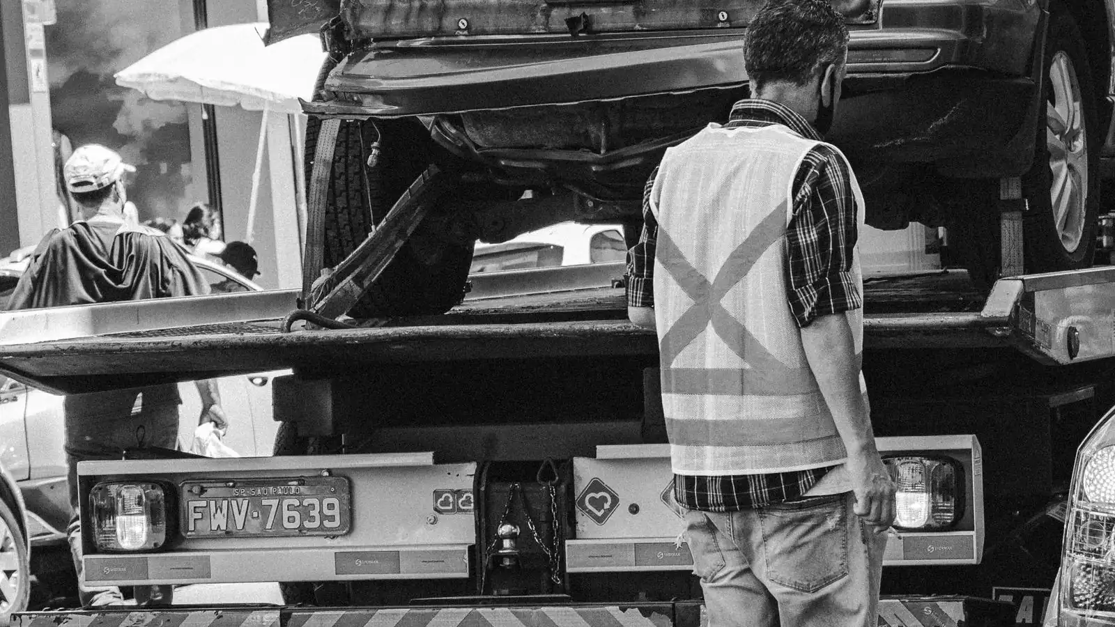 Guincho carregando veículo em rua da cidade, representando a apreensão do carro financiado